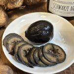Schwarze Nüsse aufgeschnitten zu Fondue oder Raclette