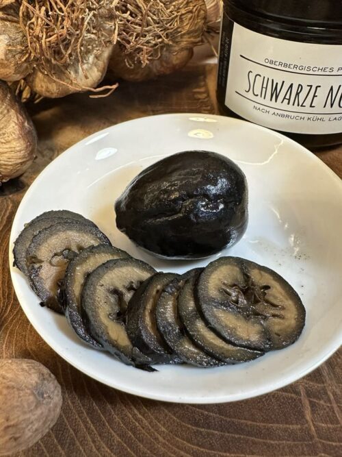 Schwarze Nüsse aufgeschnitten zu Fondue oder Raclette