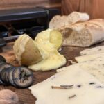 Raclette-Käse aus der Schweiz, geschmolzen und für eine Feier angerichtet