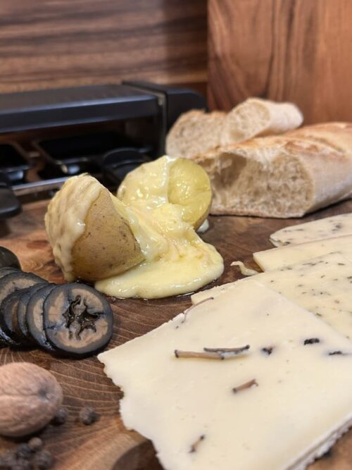 Raclette-Käse aus der Schweiz, geschmolzen und für eine Feier angerichtet